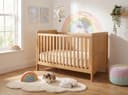 Kids Latex Mattress — in a cot in a cheerful rainbow-and-cloud themed nursery